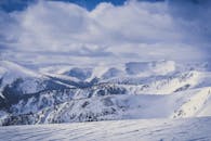 冬日，多云天空下白雪皑皑的山峰令人惊叹，捕捉到宁静的自然之美