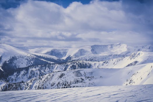冬日，多云天空下白雪皑皑的山峰令人惊叹，捕捉到宁静的自然之美