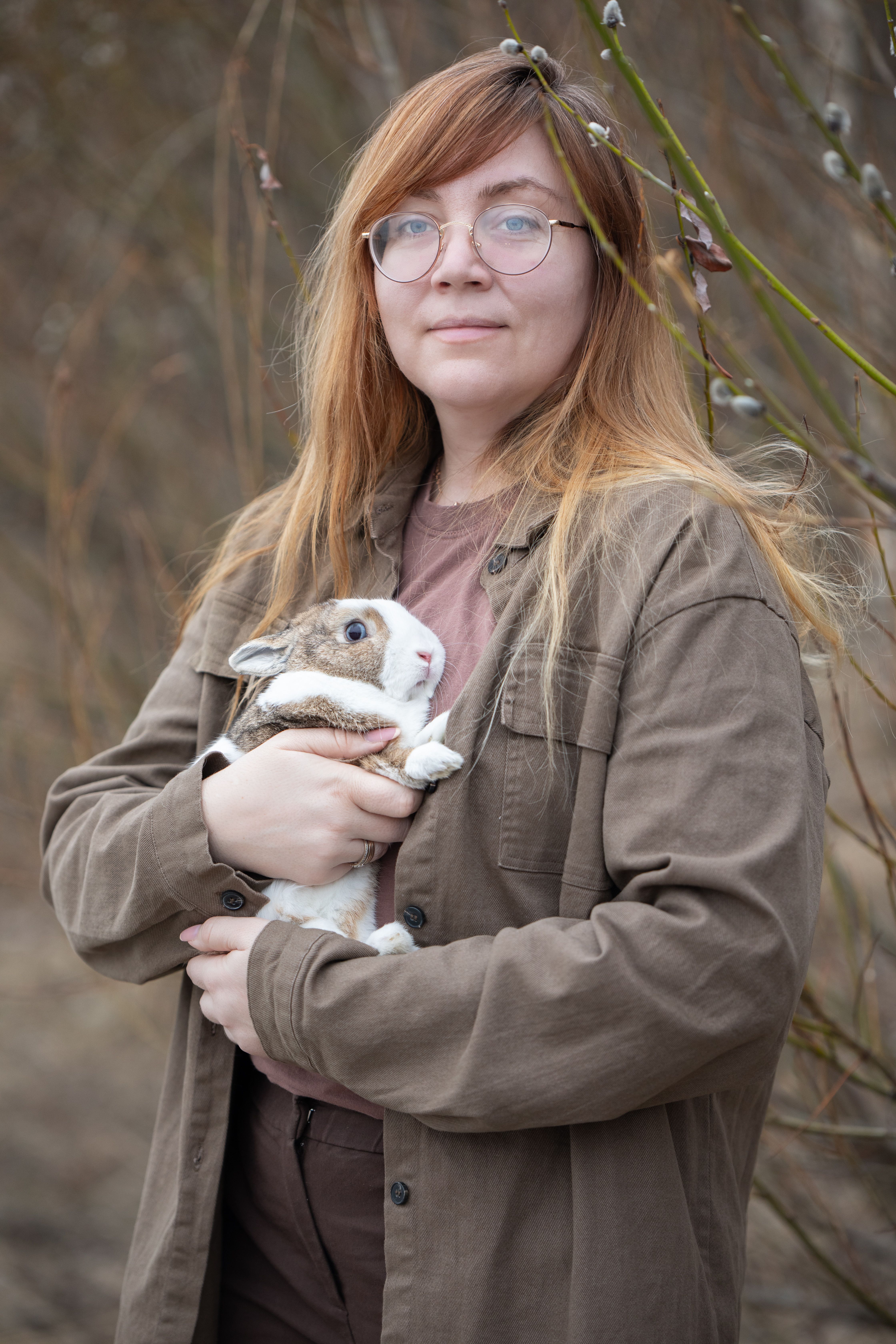 Woman with Glasses Posing with a Rabbit in Her Arms by the Forest ...