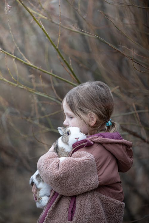 A little girl holding a rabbit in her arms