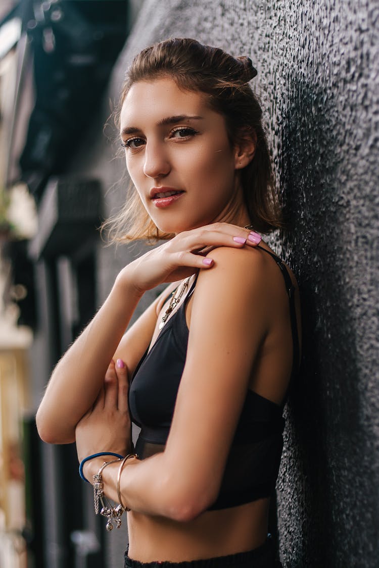 Photo Of Woman In Black Crop Top Leaning On Black Wall