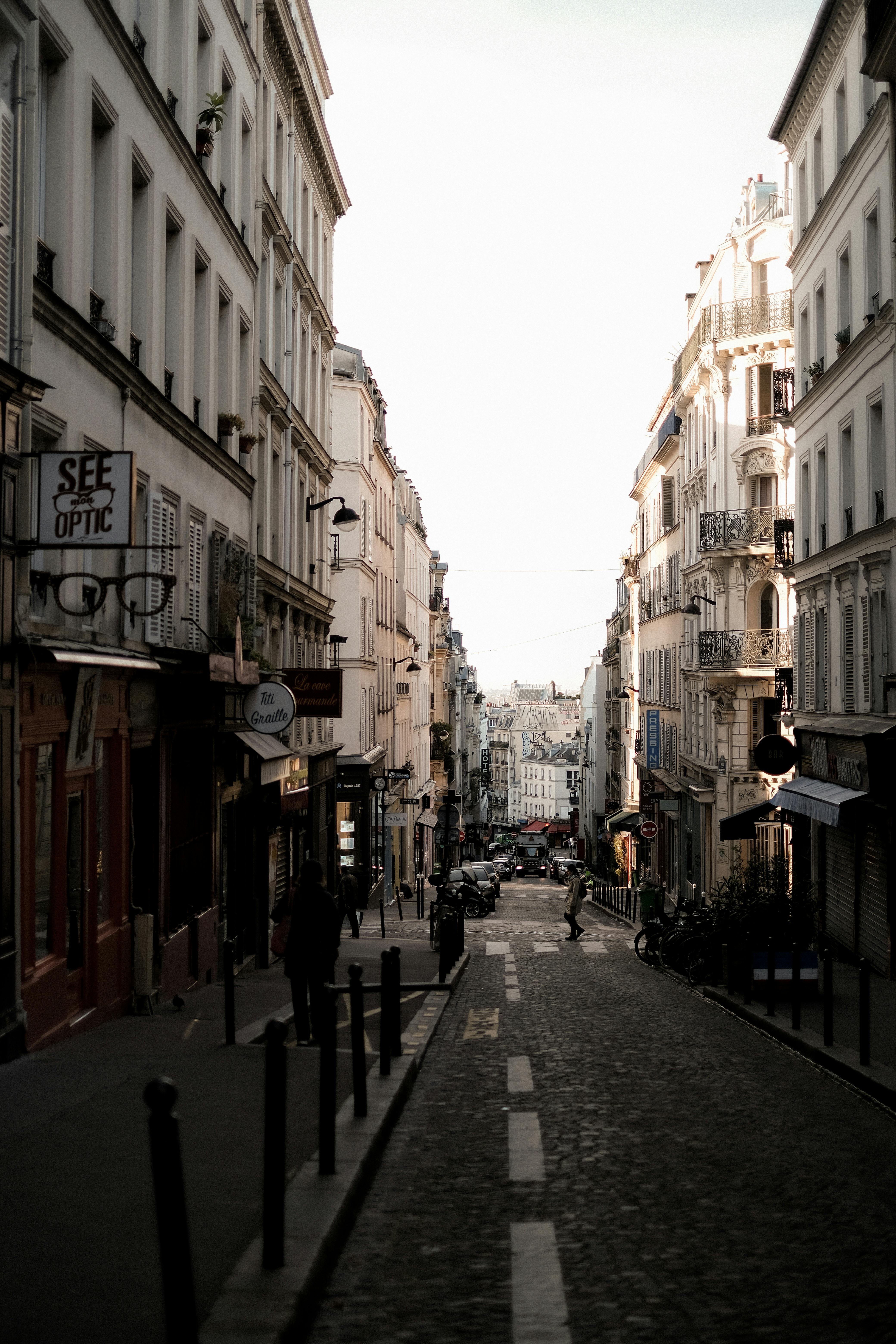 Beautiful narrow street in Paris with cobblestone path and classic architecture. Ideal for travel and architecture themes.