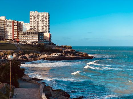 Scenic view of the oceanfront in Mar del Plata, Argentina with urban skyline and waves.