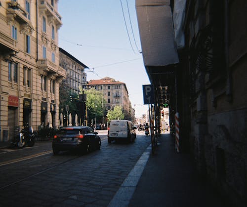 A city street with cars and buildings on both sides