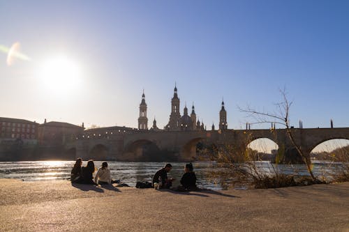 Women and Man Sitting near River in Saragossa City in Soain