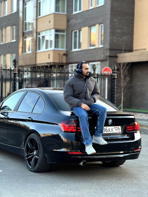 A man sitting on the back of a black bmw
