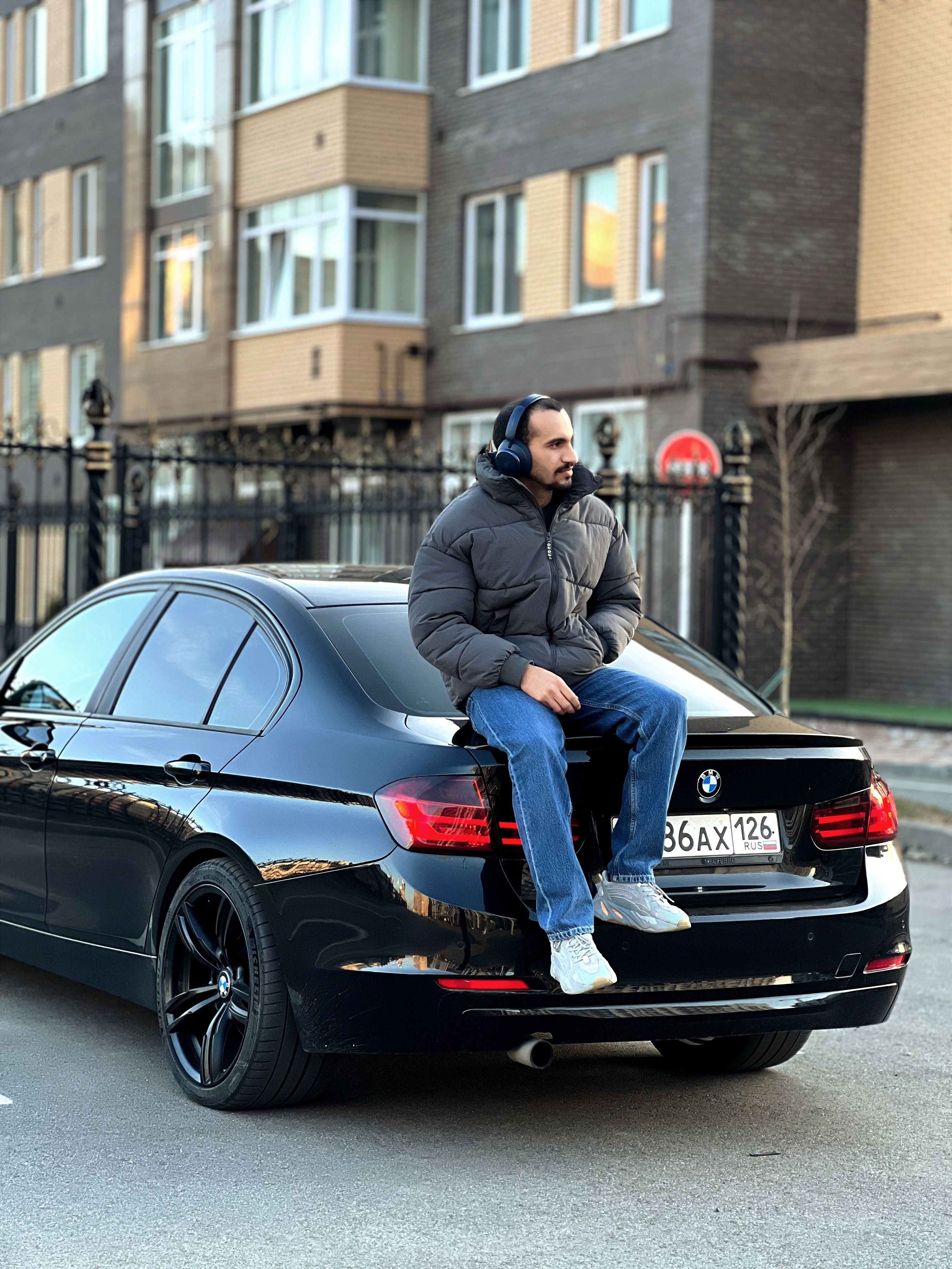 Man in Jacket Sitting on BMW Car · Free Stock Photo