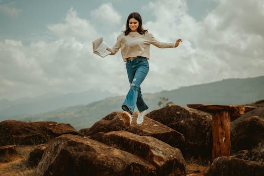 A young woman joyfully leaps over rocks in the scenic outdoors of Matale, Sri Lanka.