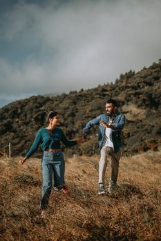 A joyful couple holds hands as they explore scenic mountains of Sri Lanka.