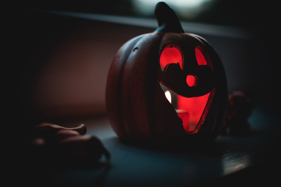 A carved pumpkin jack-o'-lantern glowing with candlelight, perfect for Halloween ambiance.