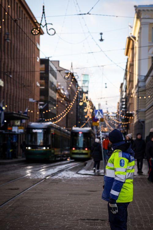 Free Winter day in Helsinki with trams and a police officer on a decorated street. Stock Photo