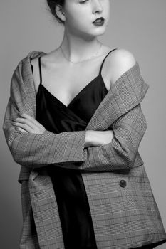 Stylish black and white portrait of a woman in a coat and dress.