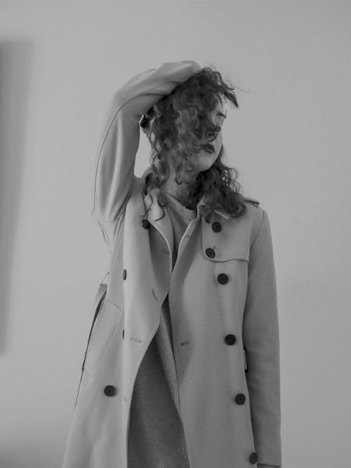 A woman in a trench coat is posing for a photo