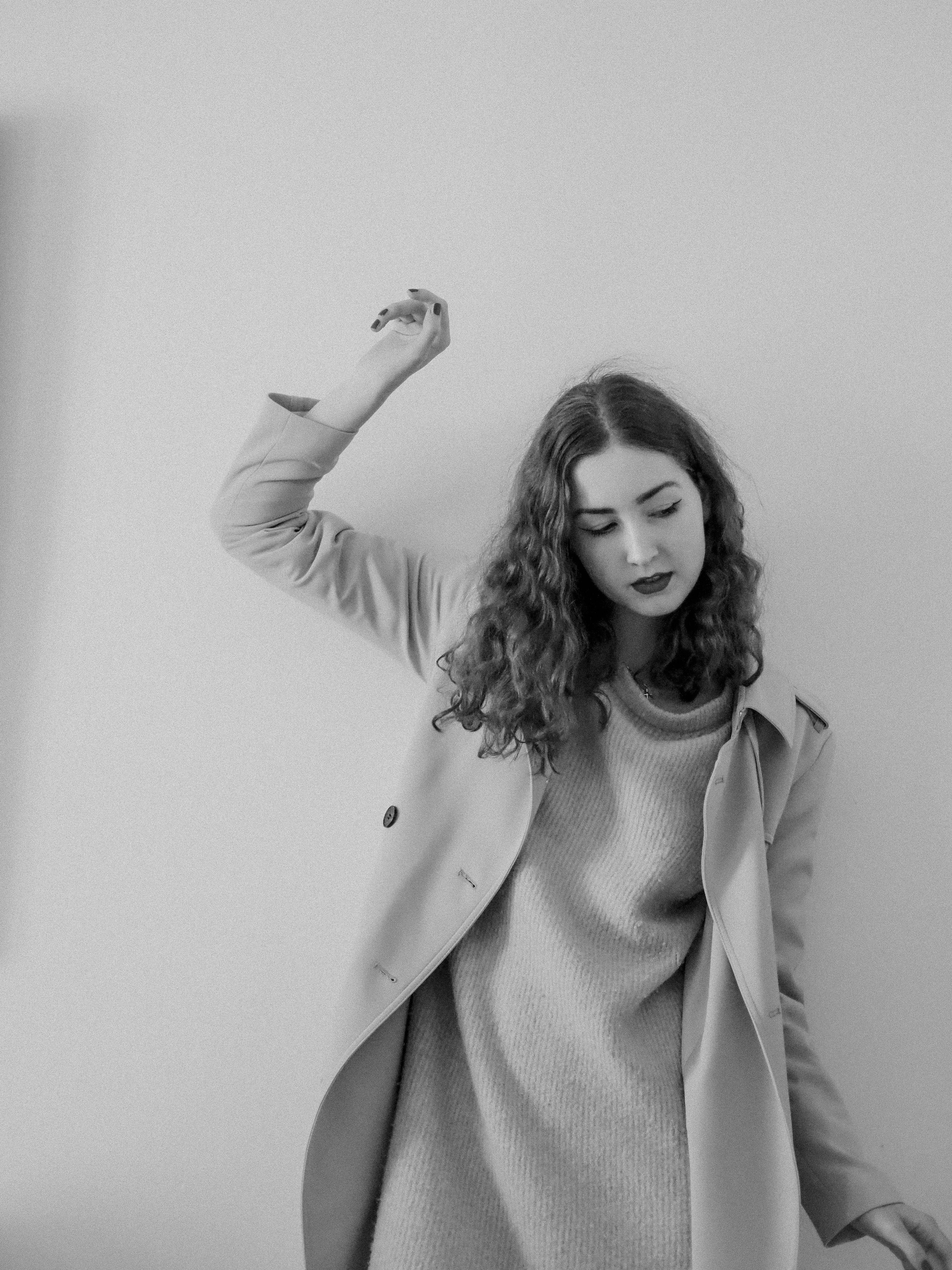woman in camel trench coat over sweater dress and boots