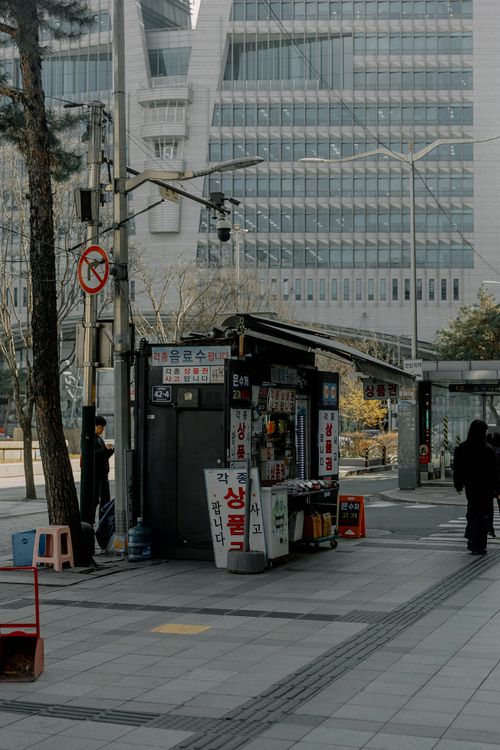 Free Street scene featuring a newsstand against modern architecture in an urban setting. Stock Photo