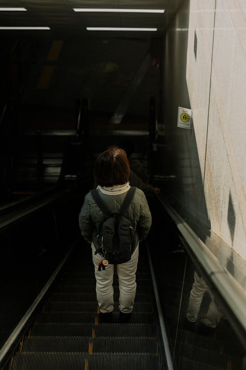 A child is walking down an escalator