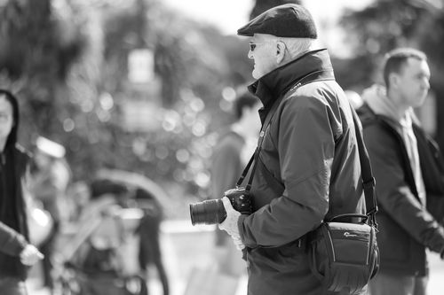 Free A senior man with a camera observes city life in Bournemouth, UK. Stock Photo