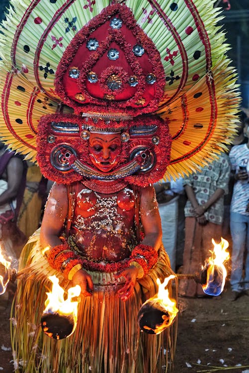 A man dressed in a costume with fire in his hands