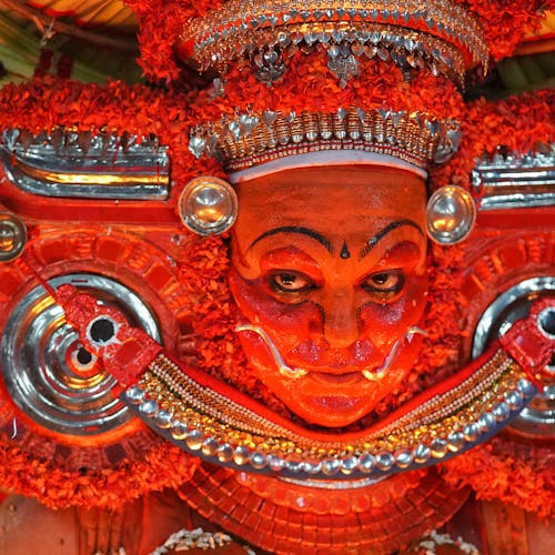 A close up of a face painted in red and orange