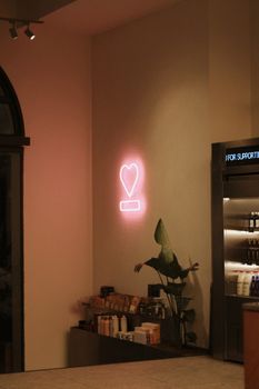 Elegant café interior featuring a pink neon heart sign, creating a cozy ambiance.