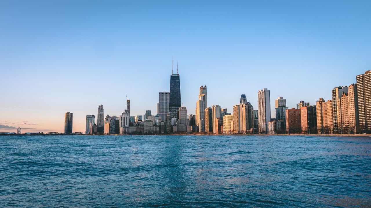 stunning view of chicago s skyline at dawn reflecting over a calm wate