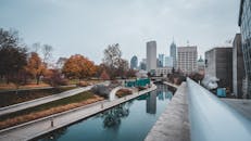 印第安纳波利斯运河的水面上，倒映着城市天际线和秋色