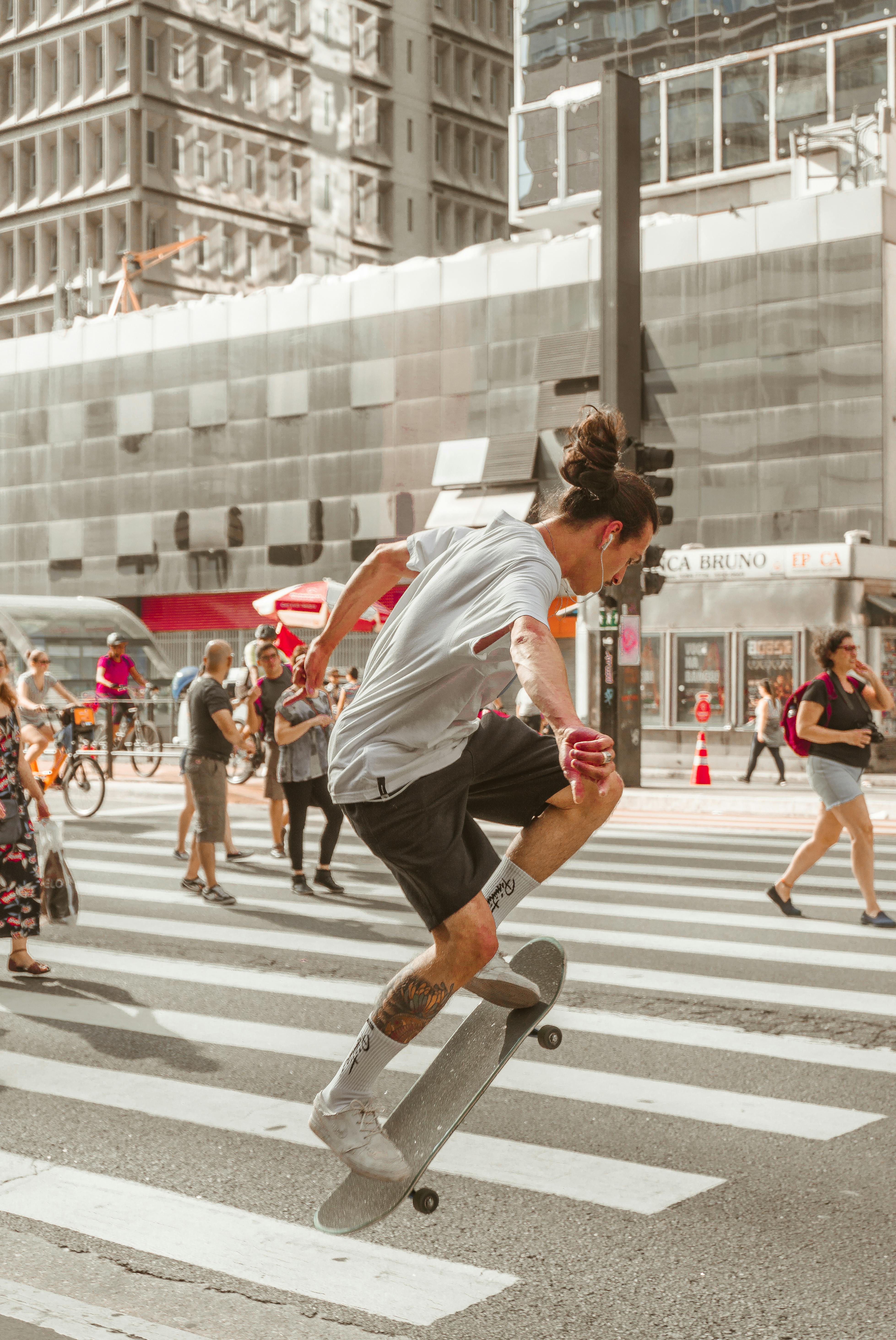 photo of man riding skateboard on pedestrian