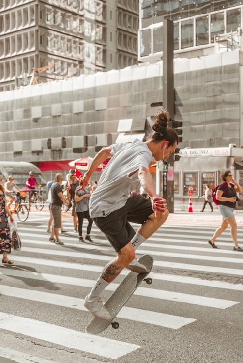 Free Photo of Man Riding Skateboard on Pedestrian Stock Photo