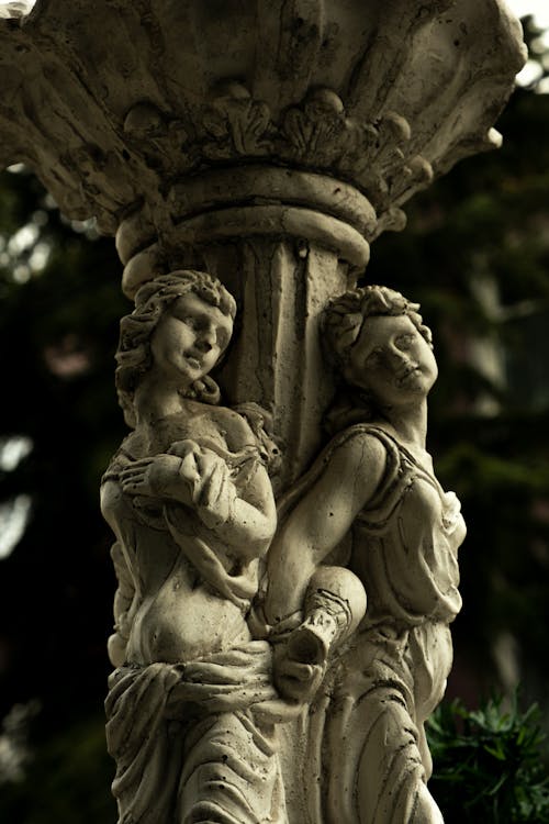 A statue of two women holding hands on a fountain