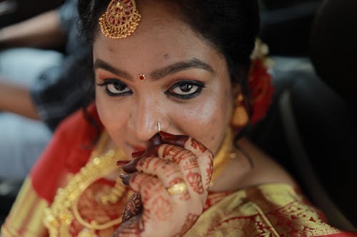 A woman in traditional indian attire with her hands on her face