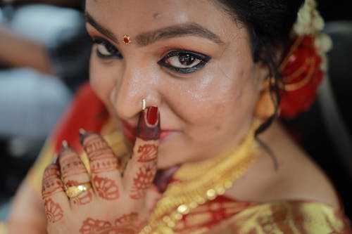 A woman with red and gold makeup and jewelry