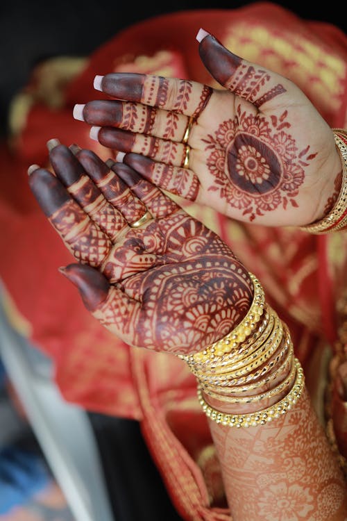 A woman's hands with henna tattoos on them