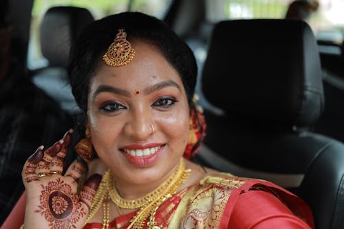 A woman in traditional indian attire smiling while on the phone