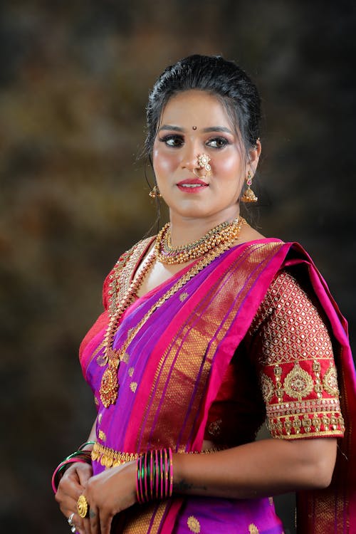 A beautiful woman in a pink and purple sari