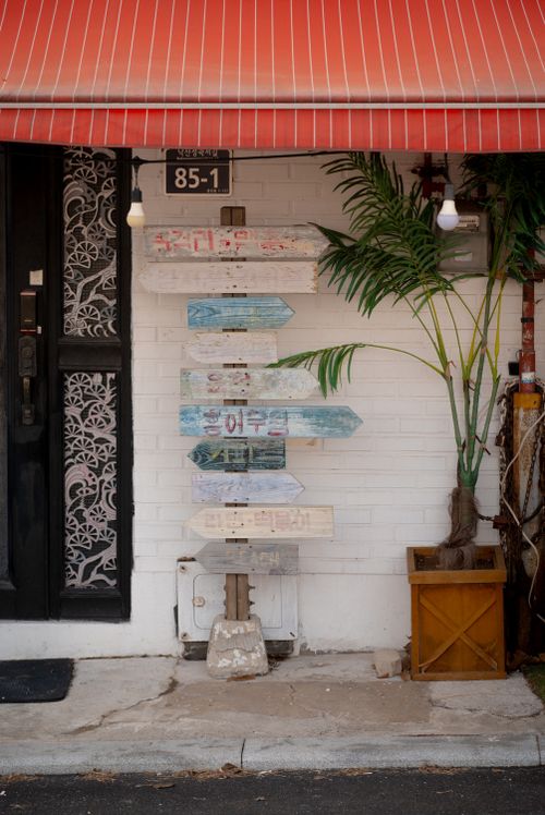 Free Urban entrance with decorative awning and rustic signpost. Ideal for travel inspiration. Stock Photo
