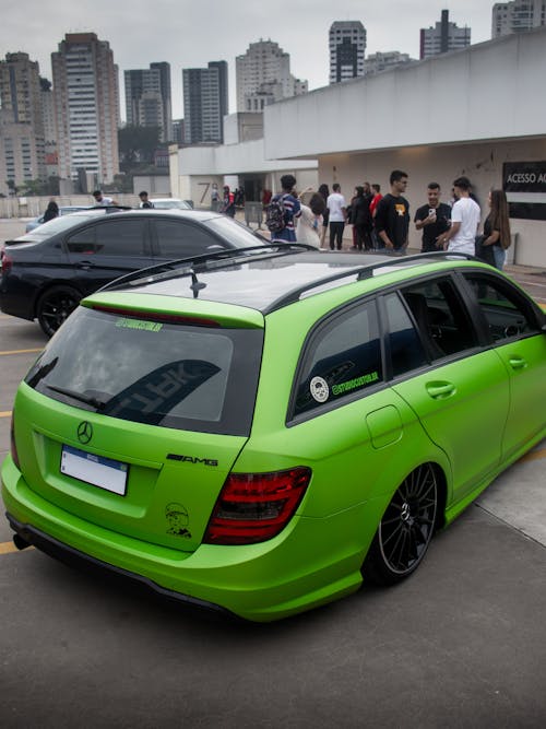 A green mercedes wagon parked in a parking lot