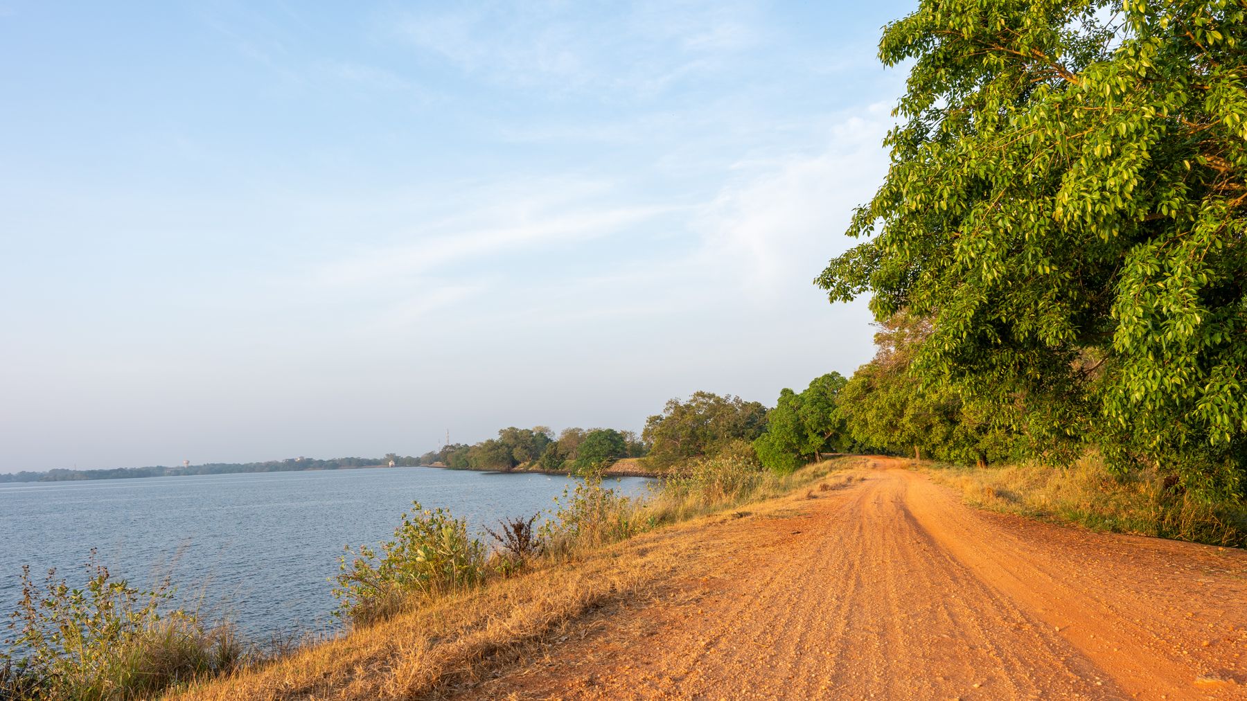 A dirt road along a body of water, Burkina Faso
