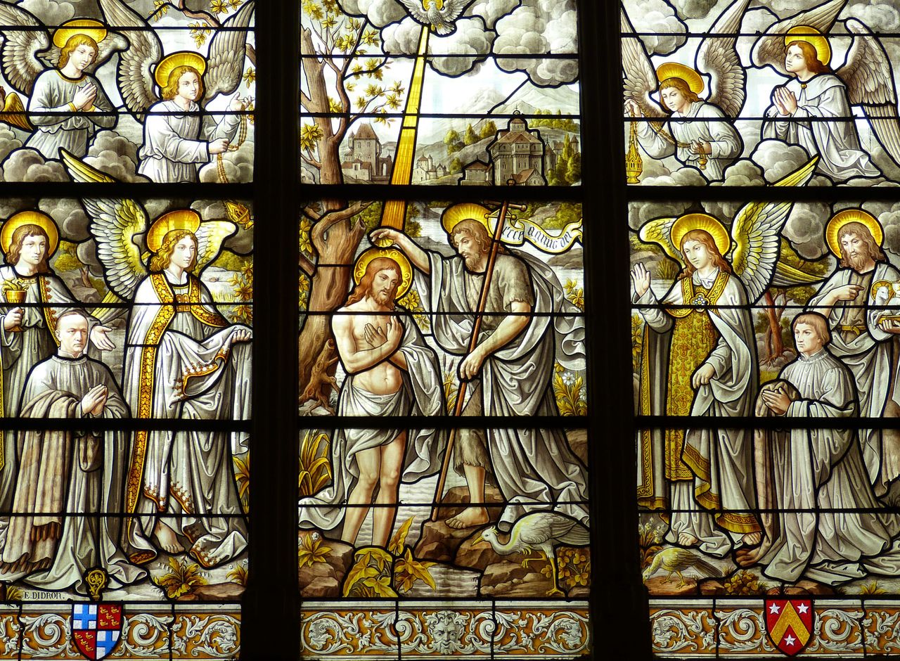 detailed stained glass artwork illustrates biblical scenes in a church