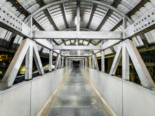 Free A long walkway with metal railings and a train Stock Photo