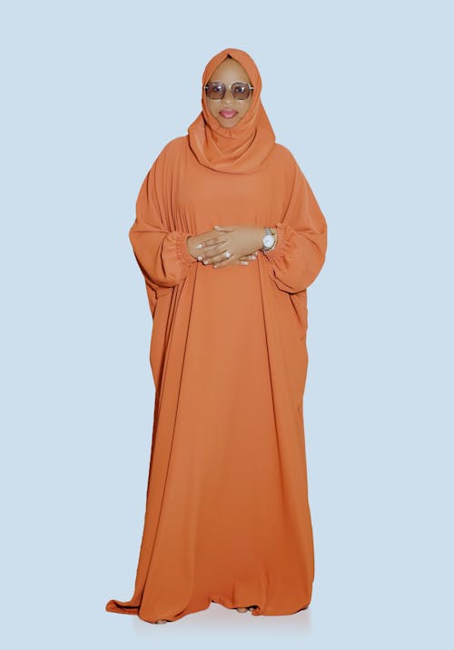 A woman in an orange hijab and glasses