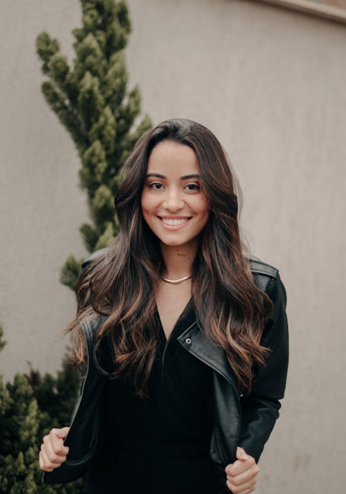 Photo of a Smiling Young Woman Wearing a Leather Jacket 