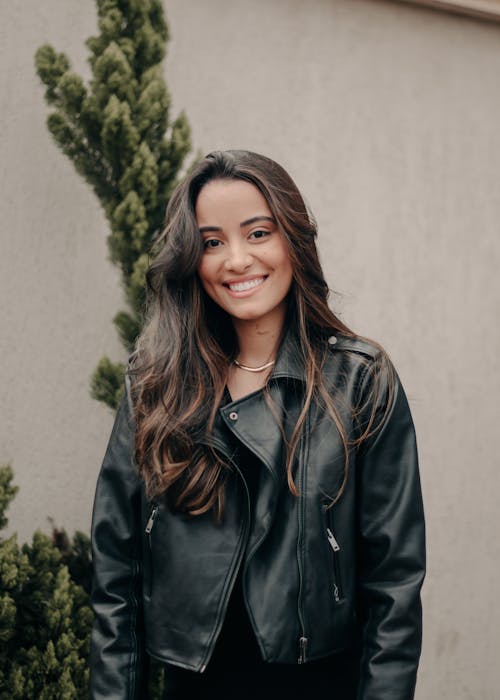 Photo of a Smiling Young Woman Wearing a Leather Jacket 