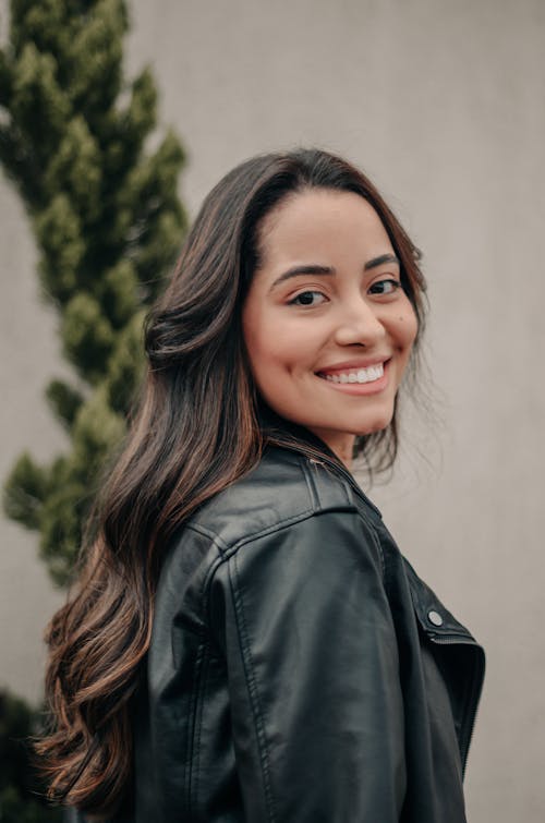 Photo of a Smiling Young Woman Wearing a Leather Jacket 