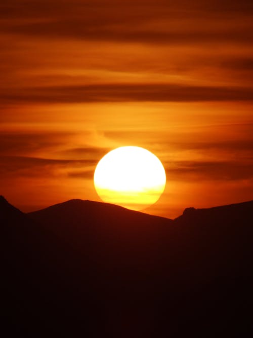 The sun is setting over a mountain range