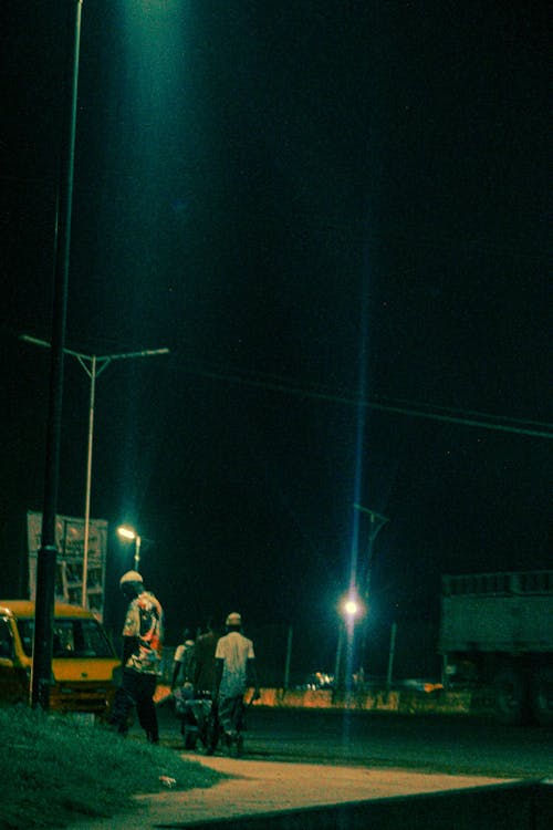 A man standing on the sidewalk at night