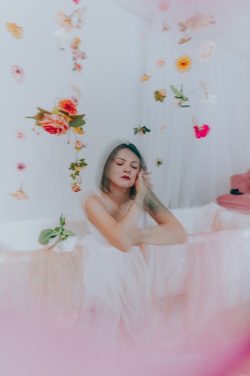 A woman in a bathtub with flowers and butterflies