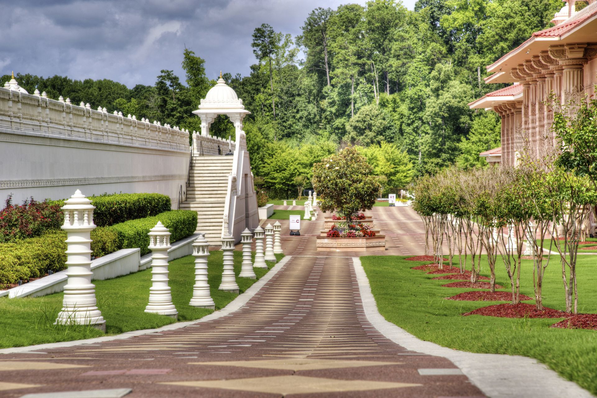 Peaceful garden view showcasing ornate architecture and lush greenery on a sunny day.
