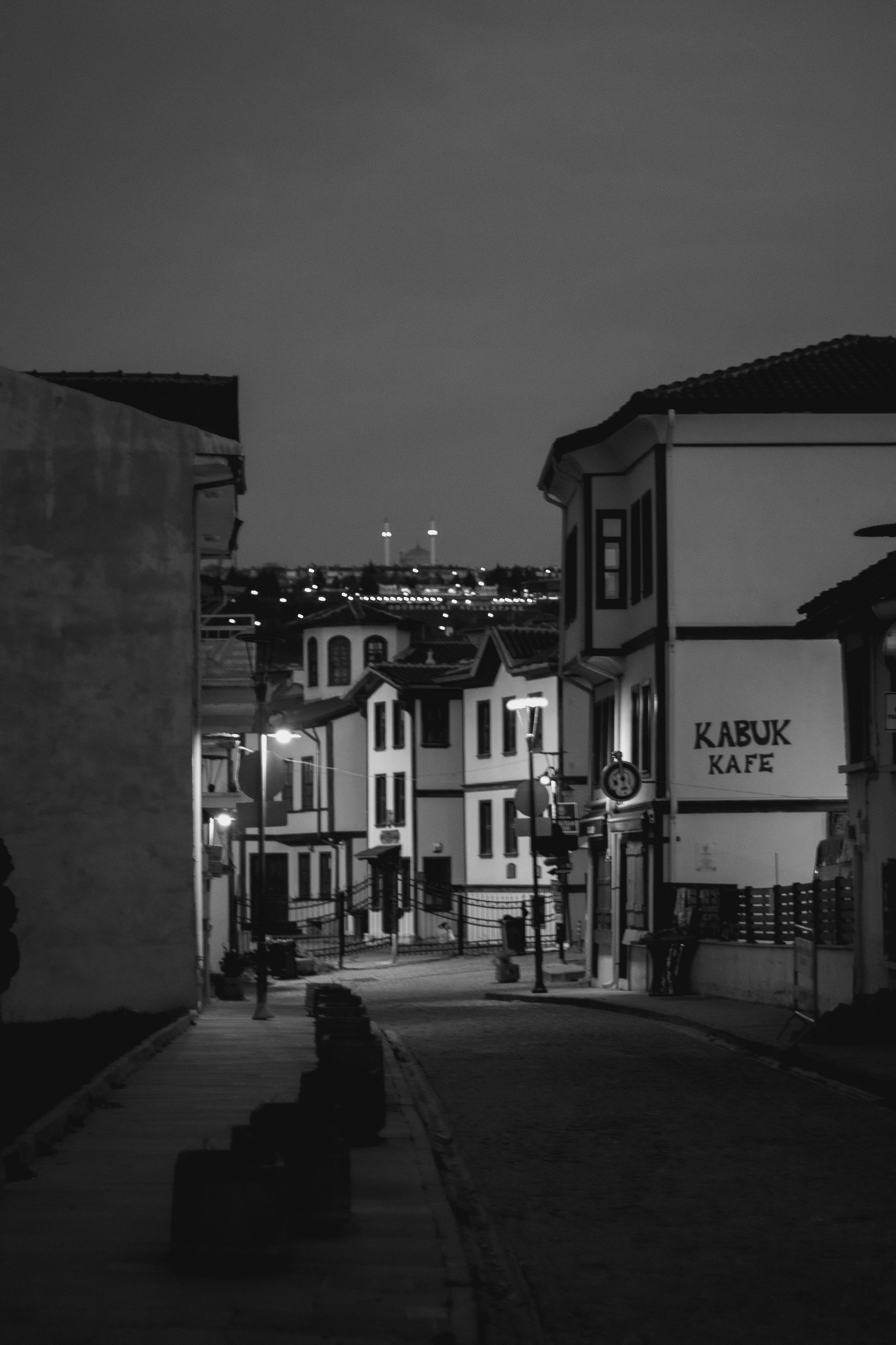 Captivating view of a narrow city street at night in Istanbul, Turkey, captured in black and white.