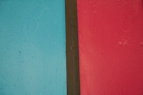 Free Close-up of a vibrant abstract wall art featuring blue and red colors divided by a brown stripe. Stock Photo