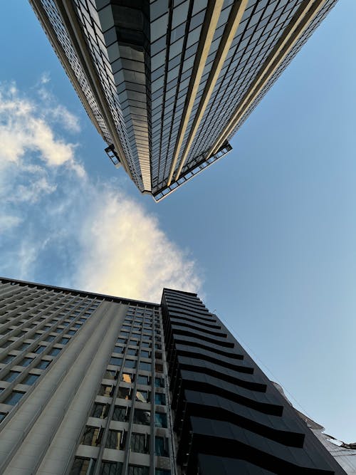 A view of two tall buildings from below